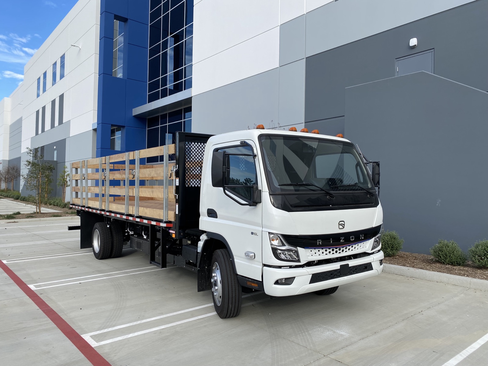 Rizon electric stake bed truck outside a warehouse